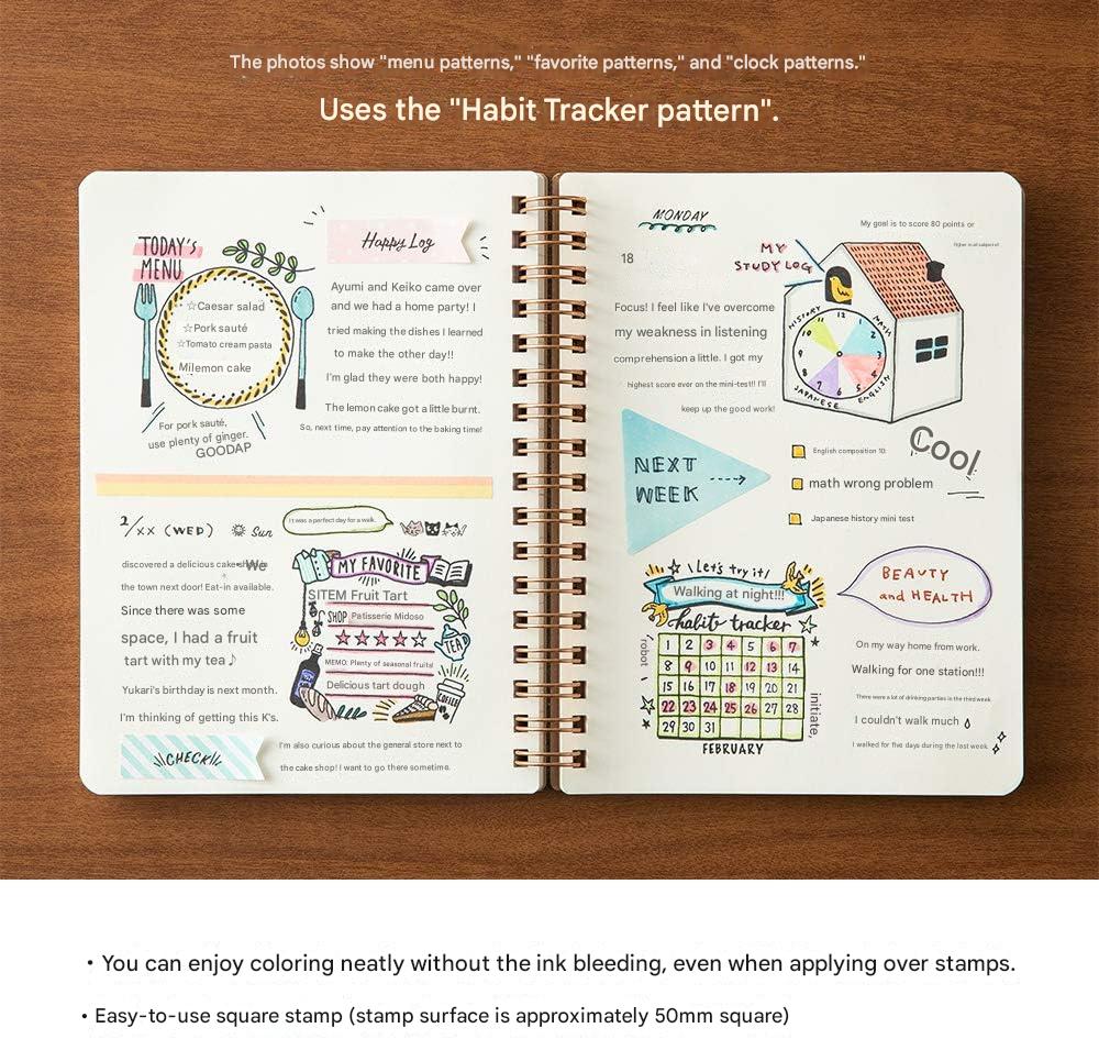 Open spiral-bound notebook displaying habit tracker patterns on a wooden surface.