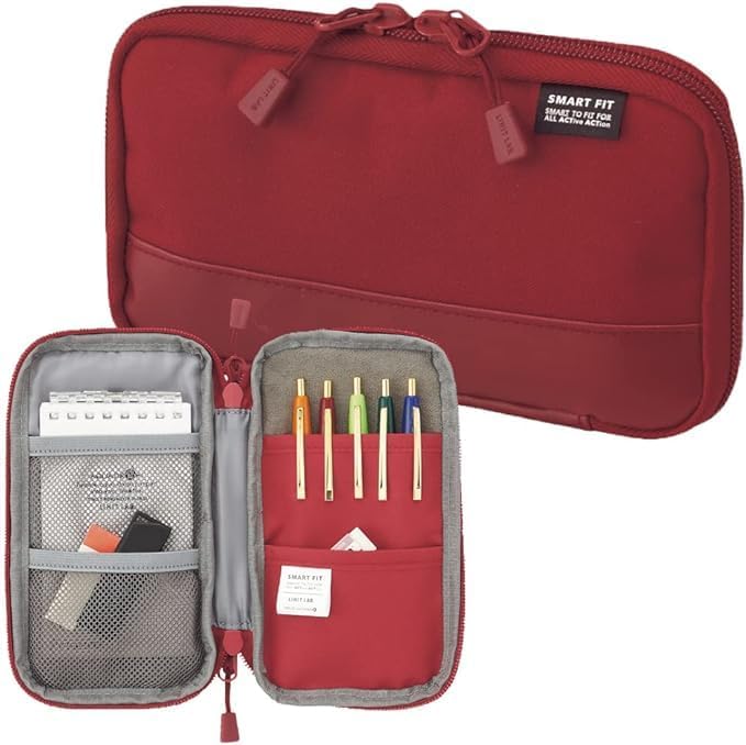 Red travel organizer with compartments and stationery items on a white background