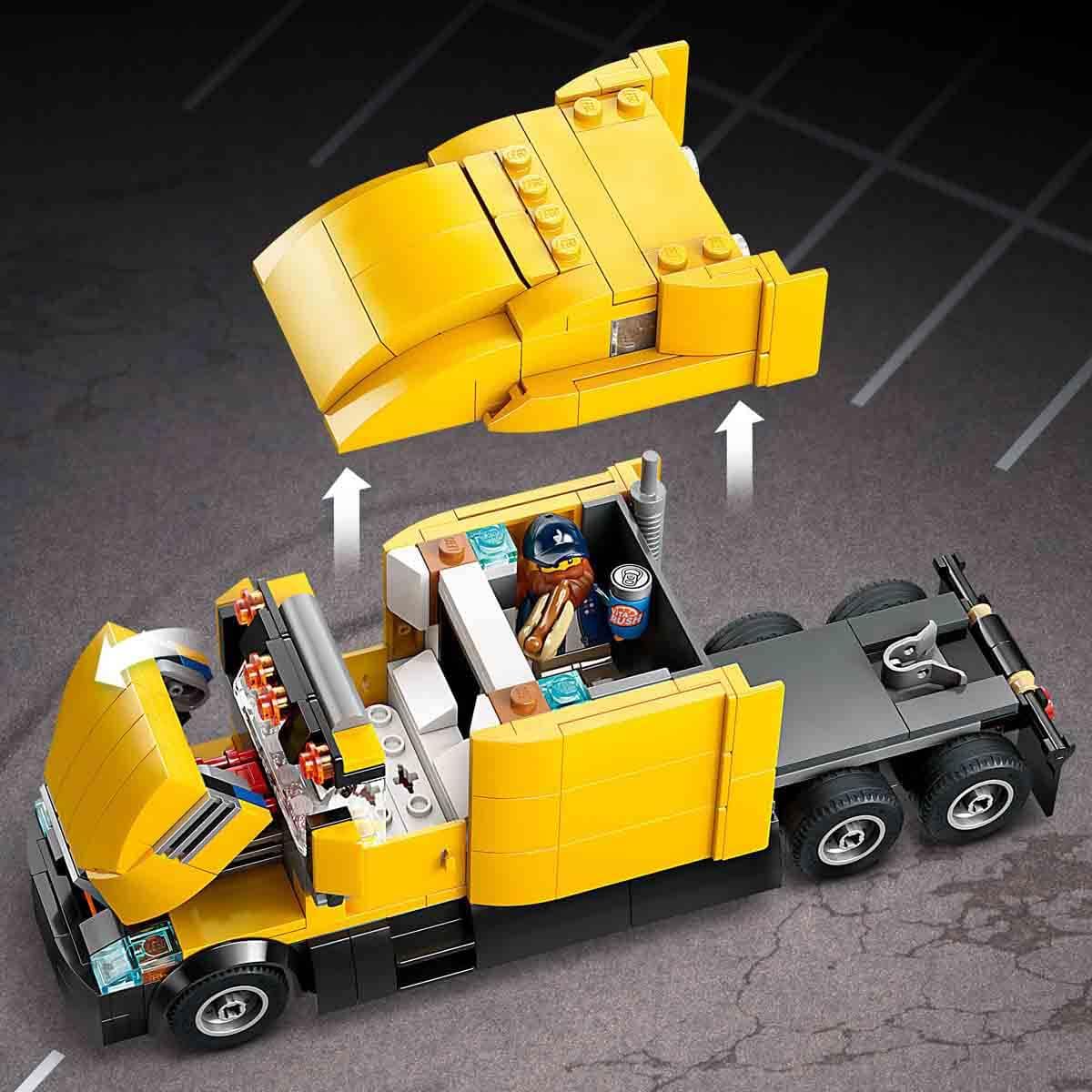 Yellow toy truck with open cargo area on a dark surface