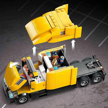 Yellow toy truck with open cargo area on a dark surface