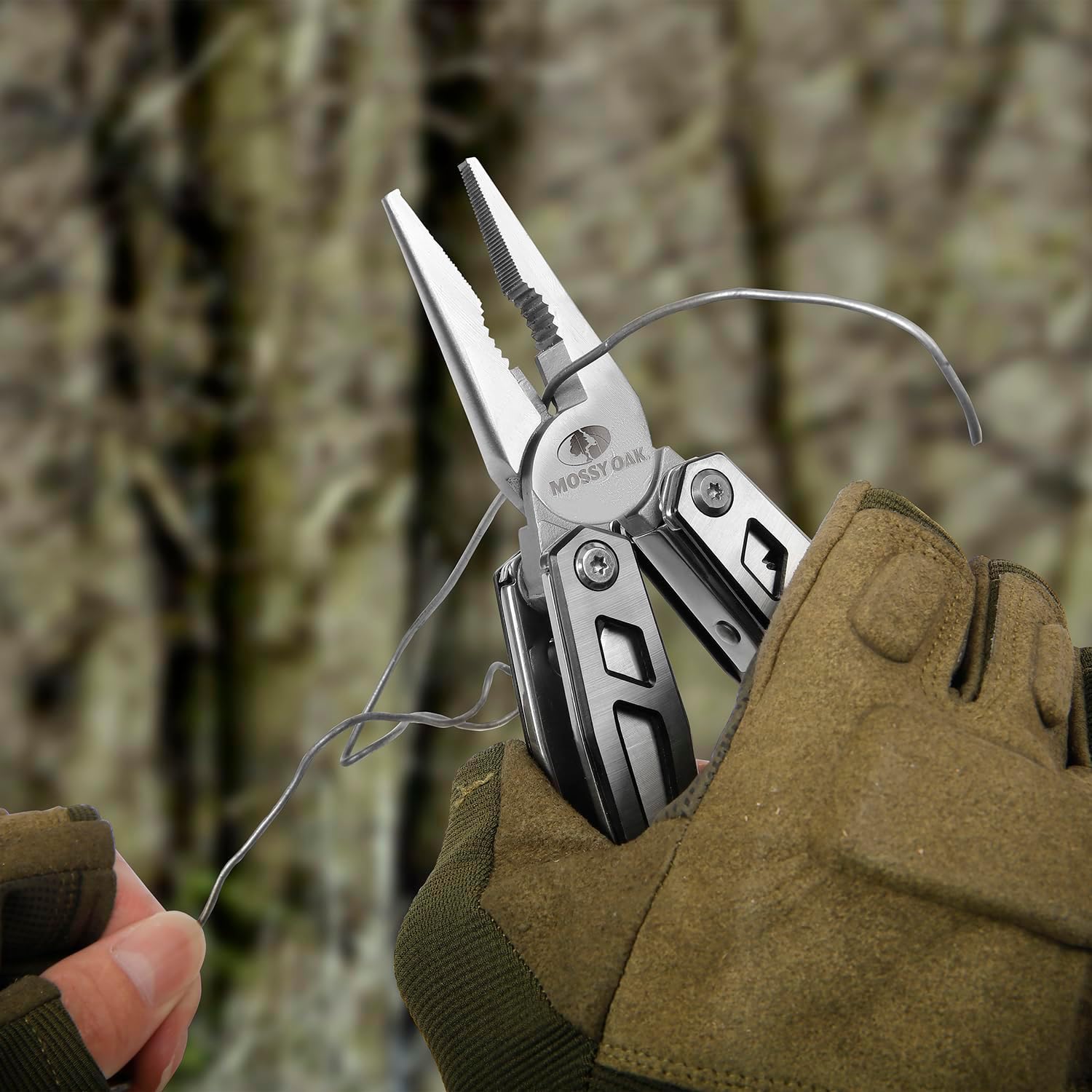 Multitool in a gloved hand with a camouflage background