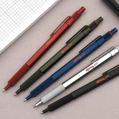 Set of six pens in red, green, blue, silver, black, and gray on a grid background