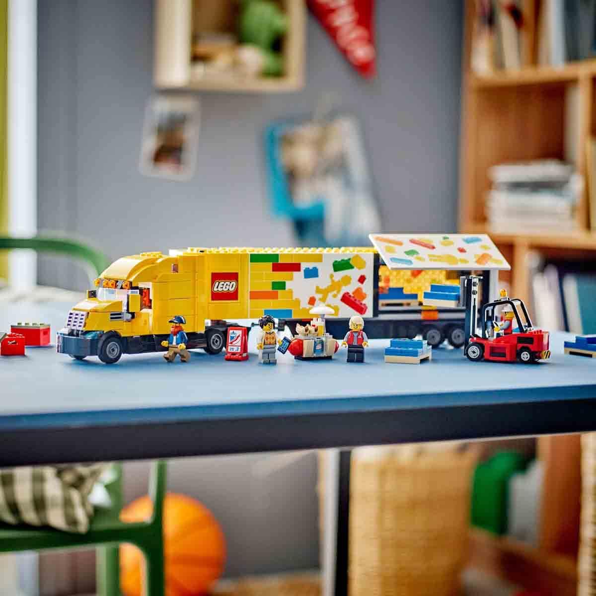 LEGO truck set on a table with various LEGO figures and items in a room setting.
